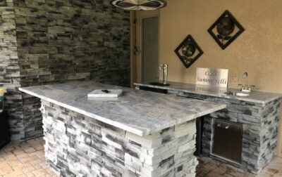 IMG_0969 Forno Nardona Tampa built outdoor kitchen/bar made of stone, granite and Lion stainless accessories with island and personalized plate "Casa Summerelli" sign.